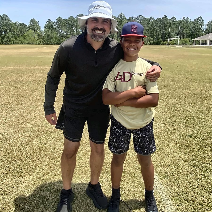 Coach Lundy with a young 4DU athlete on the field