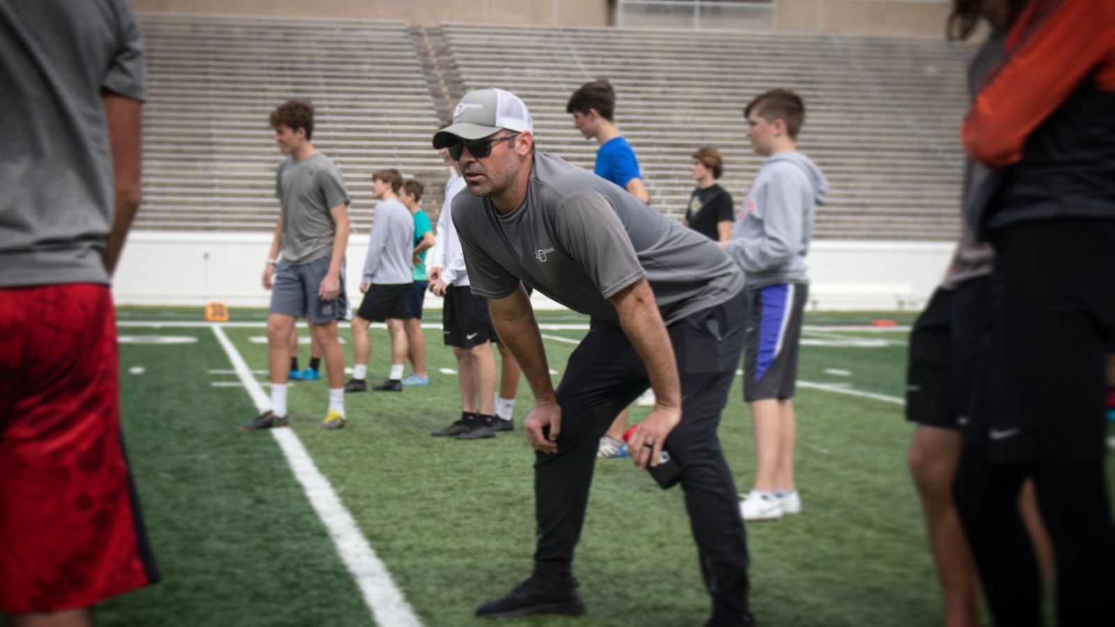 Coach Lundy coaching young kickers and punters on the field