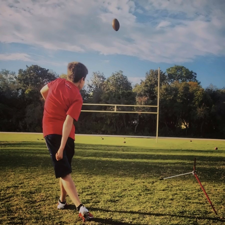 Young kicker watching his kick sail toward the uprights